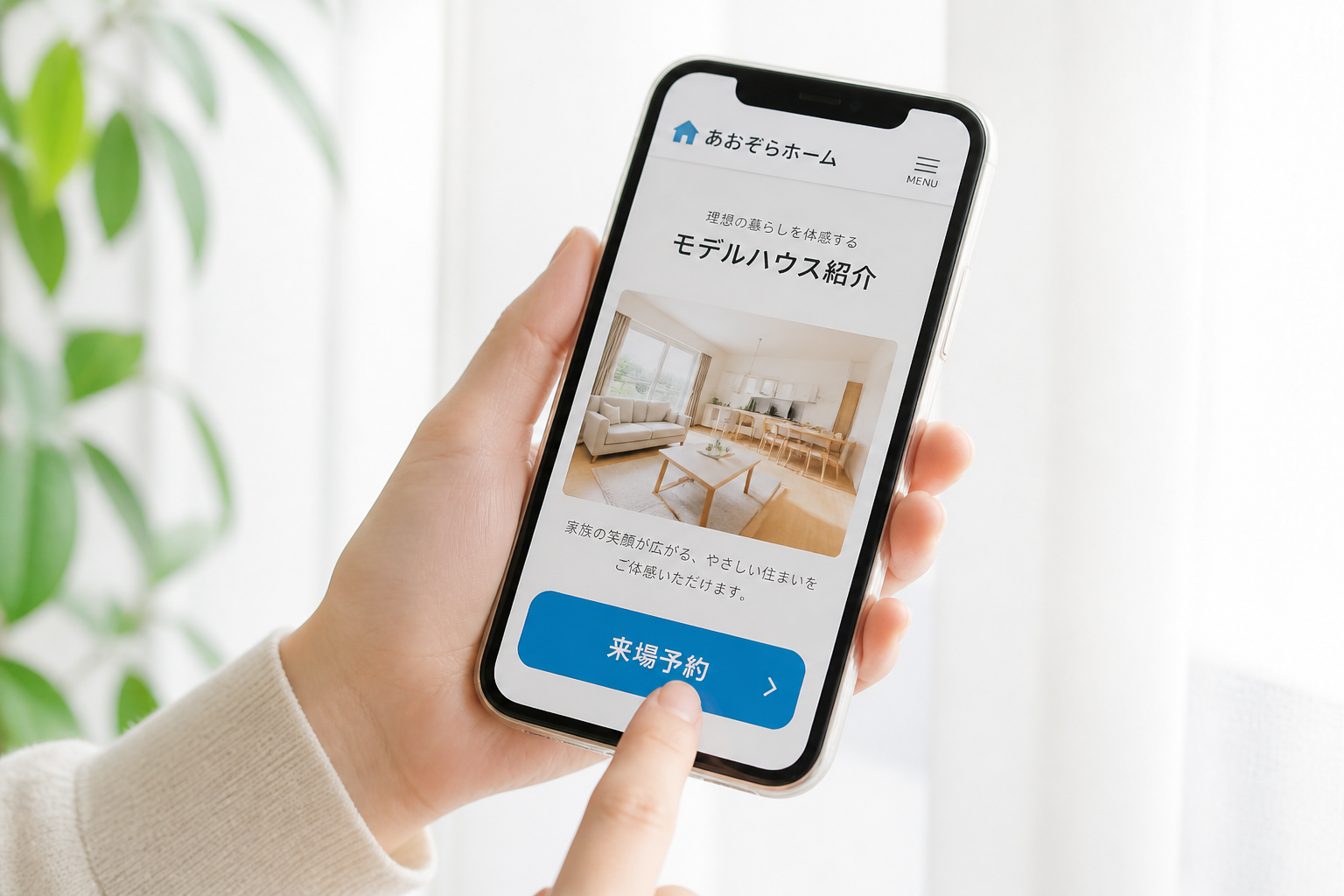 スマホでモデルハウス紹介ページの来場予約ボタンをタップしようとしている手元のマクロ接写