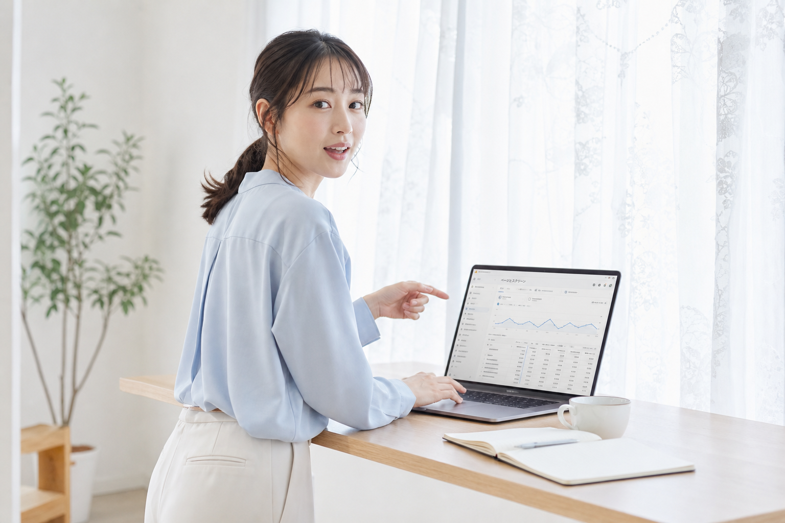 オフィスの窓際で女性担当者がGA4のページとスクリーンレポートを見ながら振り返る動作スナップ