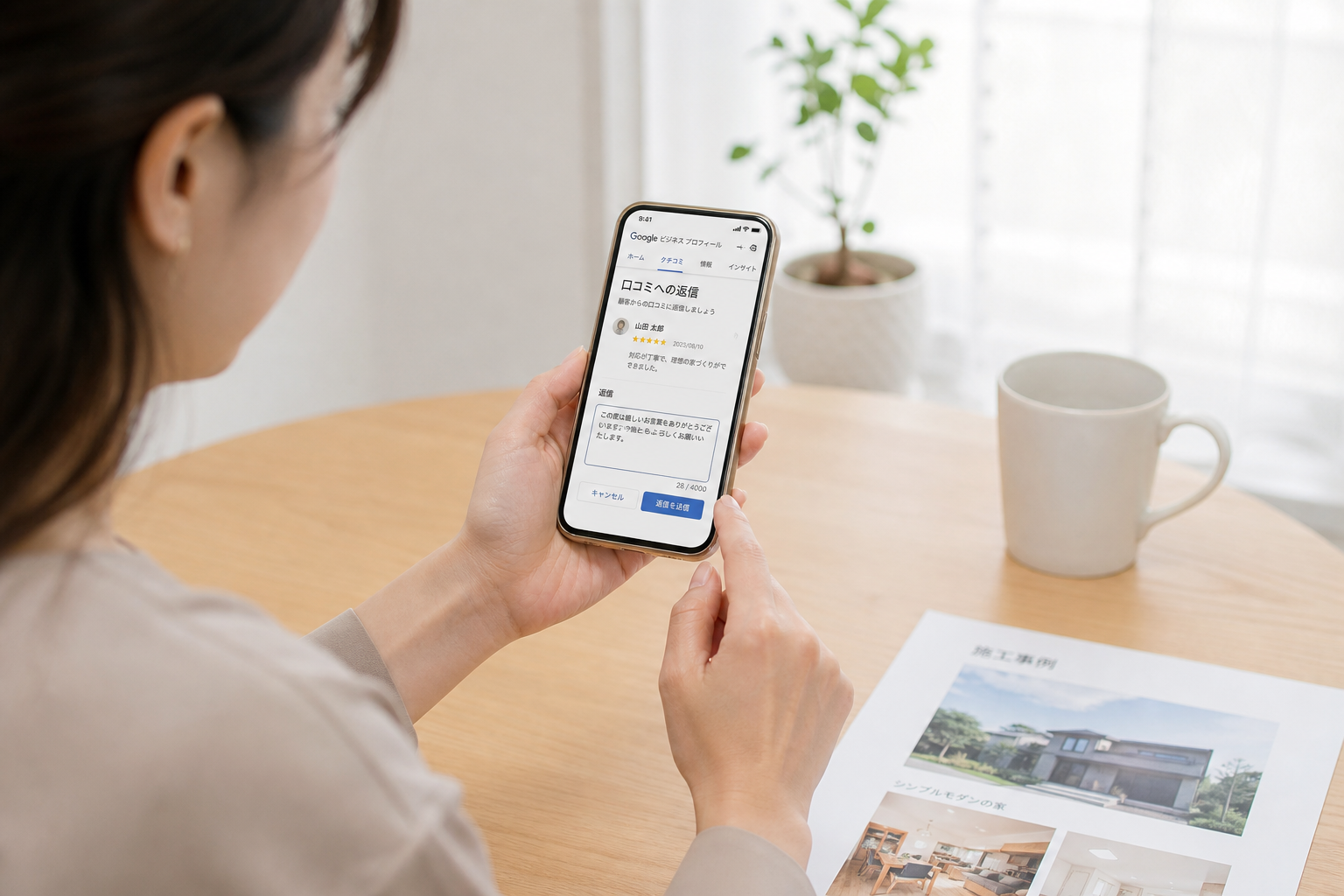 住宅会社の女性担当者がスマートフォンでGoogleビジネスプロフィールの口コミ返信画面を操作している一瞬