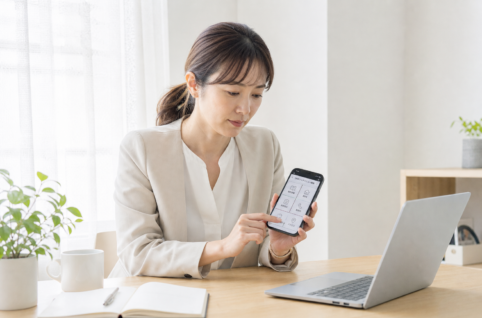 住宅会社の広報担当者がスマホのリッチメニュー編集画面を操作している一瞬。左上のマスに「来場予約」の日本語ラベルが見える